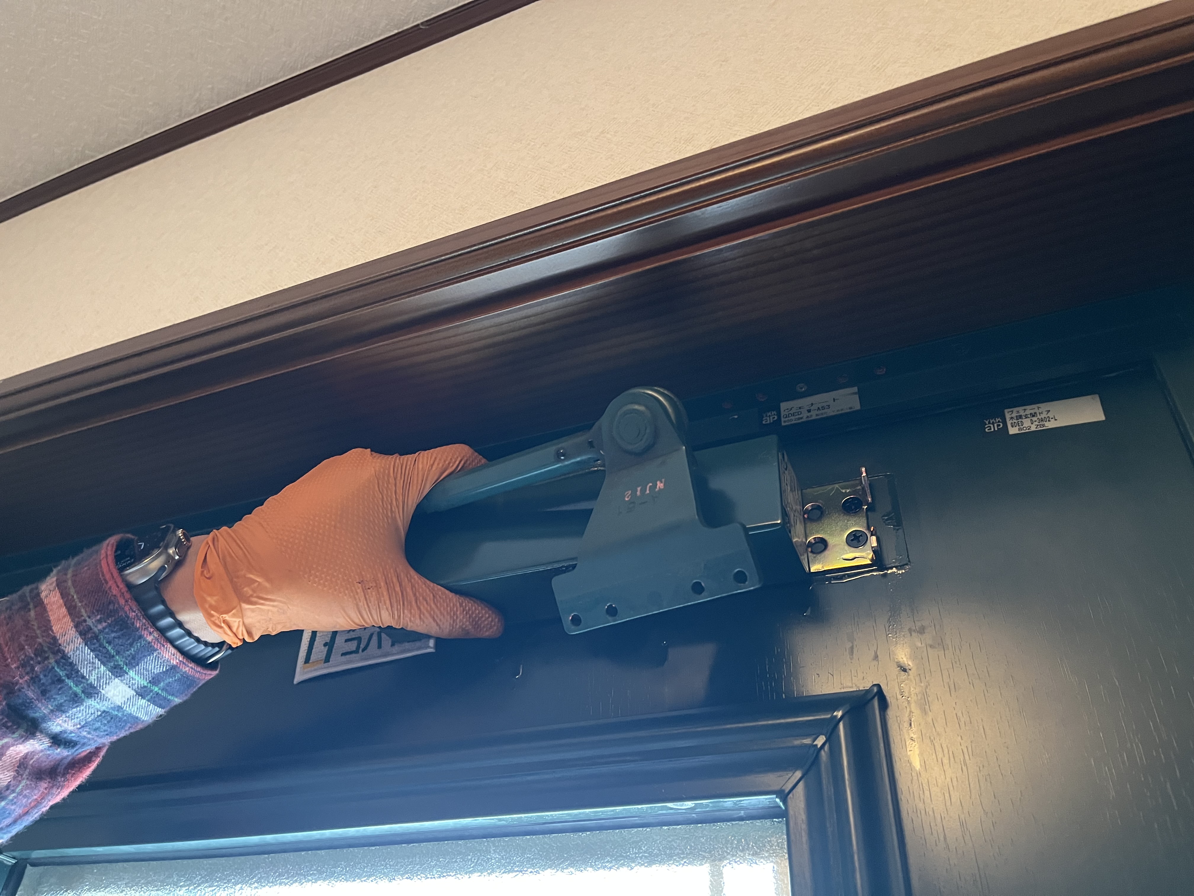 ドアクローザー本体を外側にスライドさせて取り外す作業